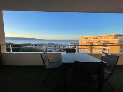 a table and chairs on a balcony with a view at Bagnu di sole - sur la route des îles sanguinaires adorable T2 vue mer in Ajaccio
