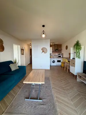 a living room with a blue couch and a table at Bagnu di sole - sur la route des îles sanguinaires adorable T2 vue mer in Ajaccio