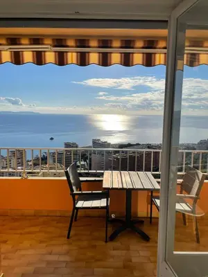 a balcony with a table and chairs and a view of the ocean at Splendide vue dans ce studio ! in Ajaccio