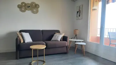 a living room with a couch and two tables at Splendide vue dans ce studio ! in Ajaccio