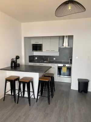 a kitchen with a large counter with stools in it at Splendide vue dans ce studio ! in Ajaccio