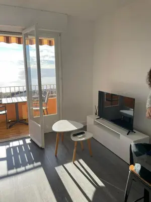 a living room with a couch and a tv and a table at Splendide vue dans ce studio ! in Ajaccio
