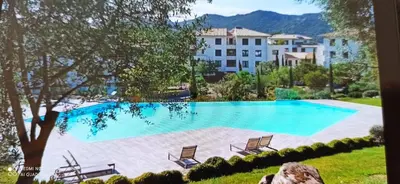 a large swimming pool with chairs and a building at ARCA C14 in Porto-Vecchio