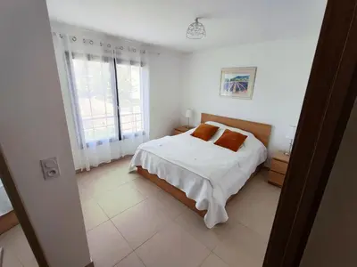 a white bedroom with a bed and a window at ARCA C14 in Porto-Vecchio