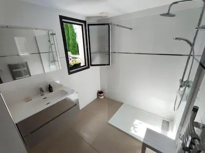 a white bathroom with a sink and a window at ARCA C14 in Porto-Vecchio