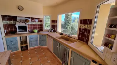 a kitchen with blue cabinets and a sink and a window at CASA SOPRANA - HAUT DE VILLA indépendant avec piscine et jardin privés - Independant TOP OF VILLA with private pool and garden in Porto-Vecchio