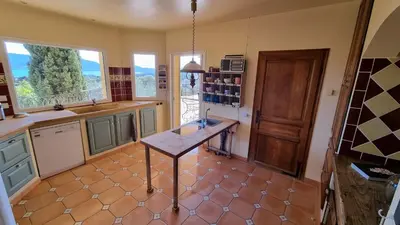a kitchen with a table in the middle of a room at CASA SOPRANA - HAUT DE VILLA indépendant avec piscine et jardin privés - Independant TOP OF VILLA with private pool and garden in Porto-Vecchio