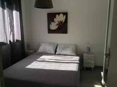 a bedroom with a bed and a painting on the wall at Coquet appartement indépendant entre mer et maquis in Sotta