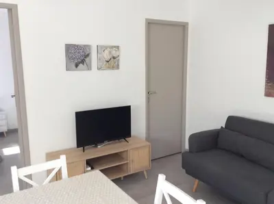a living room with a couch and a television on a table at Coquet appartement indépendant entre mer et maquis in Sotta