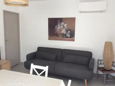 a living room with a couch and a painting on the wall at Coquet appartement indépendant entre mer et maquis in Sotta
