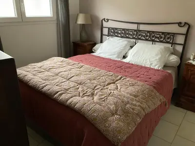 a bed with a red blanket and white pillows at Maison Le Prunier avec piscine - Domaine E Case Di Cuttoli in Cuttoli-Corticchiato