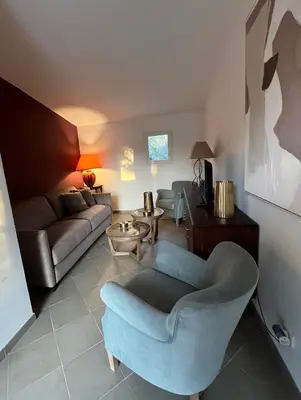 a living room with a couch and a chair at Maison Le Prunier avec piscine - Domaine E Case Di Cuttoli in Cuttoli-Corticchiato