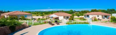 a swimming pool with two chairs and a house at Alzitone in Ghisonaccia