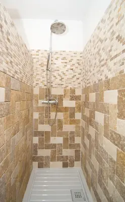 a bathroom with a shower with tiled walls at Alzitone in Ghisonaccia