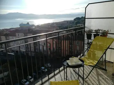 a yellow chair sitting on top of a balcony at Centre ville avec vue magnifique sur le golfe d'Ajaccio; parking privé. in Ajaccio