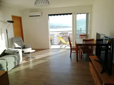 a living room with a couch and a table and chairs at Centre ville avec vue magnifique sur le golfe d'Ajaccio; parking privé. in Ajaccio