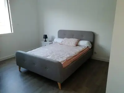 a bed in a white room with a bed frame at Centre ville avec vue magnifique sur le golfe d'Ajaccio; parking privé. in Ajaccio