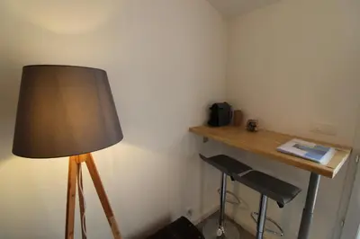 a lamp in a corner with a table and a stool at Rogliano in Porto-Vecchio