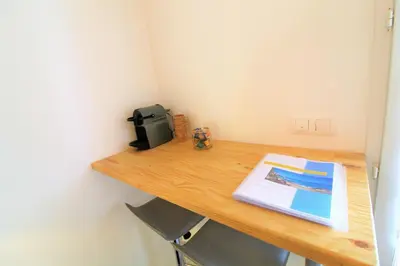 a wooden desk with a microwave and a book on it at Rogliano in Porto-Vecchio