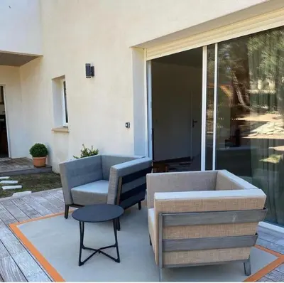 a patio with a couch and a chair and a table at Chambre à Louer sur bonifacio in Bonifacio