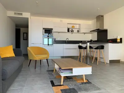 a living room with a couch and a table at Appartement T3 de standing, vue mer - Porticcio in Grosseto-Prugna