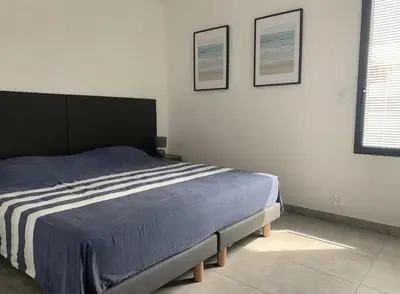 a bedroom with a bed and two pictures on the wall at Appartement T3 de standing, vue mer - Porticcio in Grosseto-Prugna