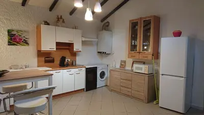 a kitchen with white cabinets and a white refrigerator at maisonnette à la campagne in San-Gavino-di-Carbini