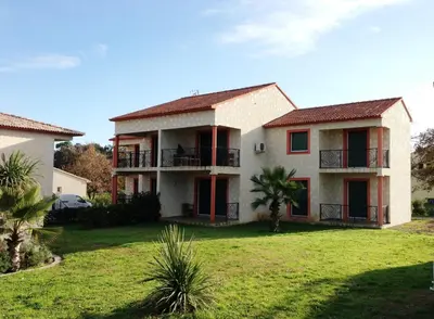 a living room with a couch and a table at T-2 air conditioning close to the sea - equipped beach - Santa Lucia di Moriani in San-Nicolao