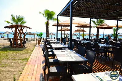a restaurant on the beach with tables and umbrellas at T-2 air conditioning close to the sea - equipped beach - Santa Lucia di Moriani in San-Nicolao