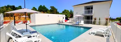a swimming pool with white chairs and an umbrella at Apartment next to the sea 4 peoples-WIFI-TV-Air Conditioning-Moriani Haute-Corse in San-Nicolao