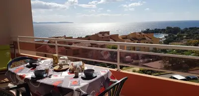 a table on a balcony with a view of the ocean at T1 vue mer bord de mer Ajaccio in Ajaccio