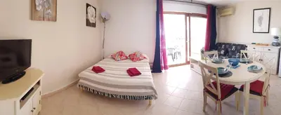 a room with a bed and a table and a television at T1 vue mer bord de mer Ajaccio in Ajaccio