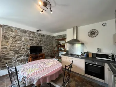 a kitchen with a table and a stove top oven at A CASA CANTUNNIERA in Pietroso