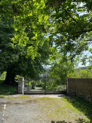 a fence with a tree in front of a park at A CASA CANTUNNIERA in Pietroso
