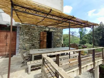 a wooden deck with a wooden pergola and benches at A CASA CANTUNNIERA in Pietroso