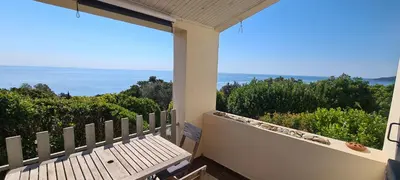a balcony with a bench and a view of the ocean at Belvedere de Canaloro in Sari Solenzara