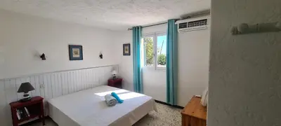 a bedroom with a white bed and a window at Belvedere de Canaloro in Sari Solenzara