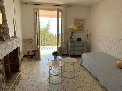 a bedroom with a bed and two tables and a fireplace at Belvedere de Canaloro in Sari Solenzara