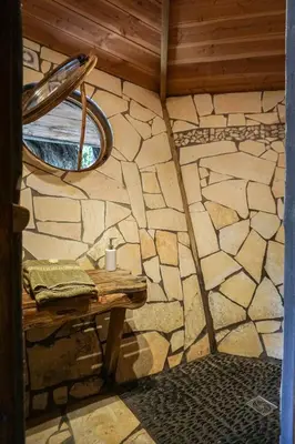 a room with a table and a stone wall at La Cabane du Bandit in Pietroso
