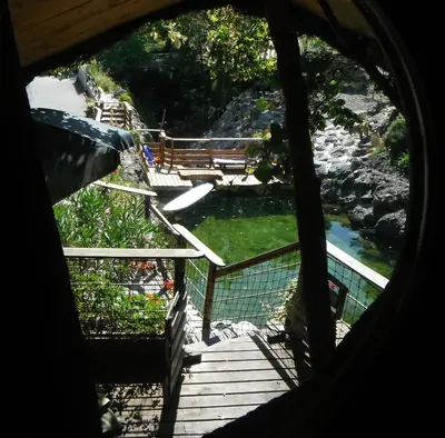 a view from a window of a wooden stairs and a river at La Cabane du Bandit in Pietroso