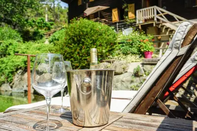 a table with two glasses and a bottle of wine at La Cabane du Bandit in Pietroso