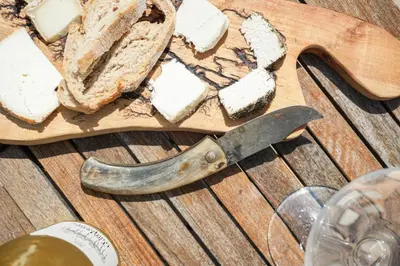 a cutting board with a loaf of bread and a knife at La Cabane du Bandit in Pietroso