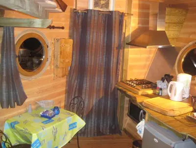 a kitchen with a table in a tiny house at La Cabane du Bandit in Pietroso