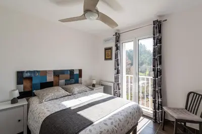 a bedroom with a bed and a ceiling fan at Le Clos d'Oletta in Oletta