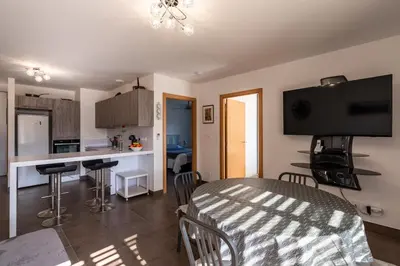 a kitchen and living room with a table and chairs at Le Clos d'Oletta in Oletta