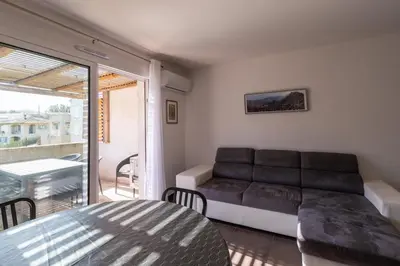 a living room with a couch and a balcony at Le Clos d'Oletta in Oletta