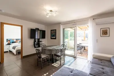 a dining room with a table and chairs and a bedroom at Le Clos d'Oletta in Oletta