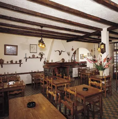 a dining room with wooden tables and chairs at Hôtel Aïtone in Evisa