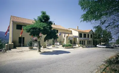 a building with a tree in front of it at Hôtel Aïtone in Evisa