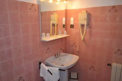 a bathroom with a sink and a mirror at Hôtel Aïtone in Evisa